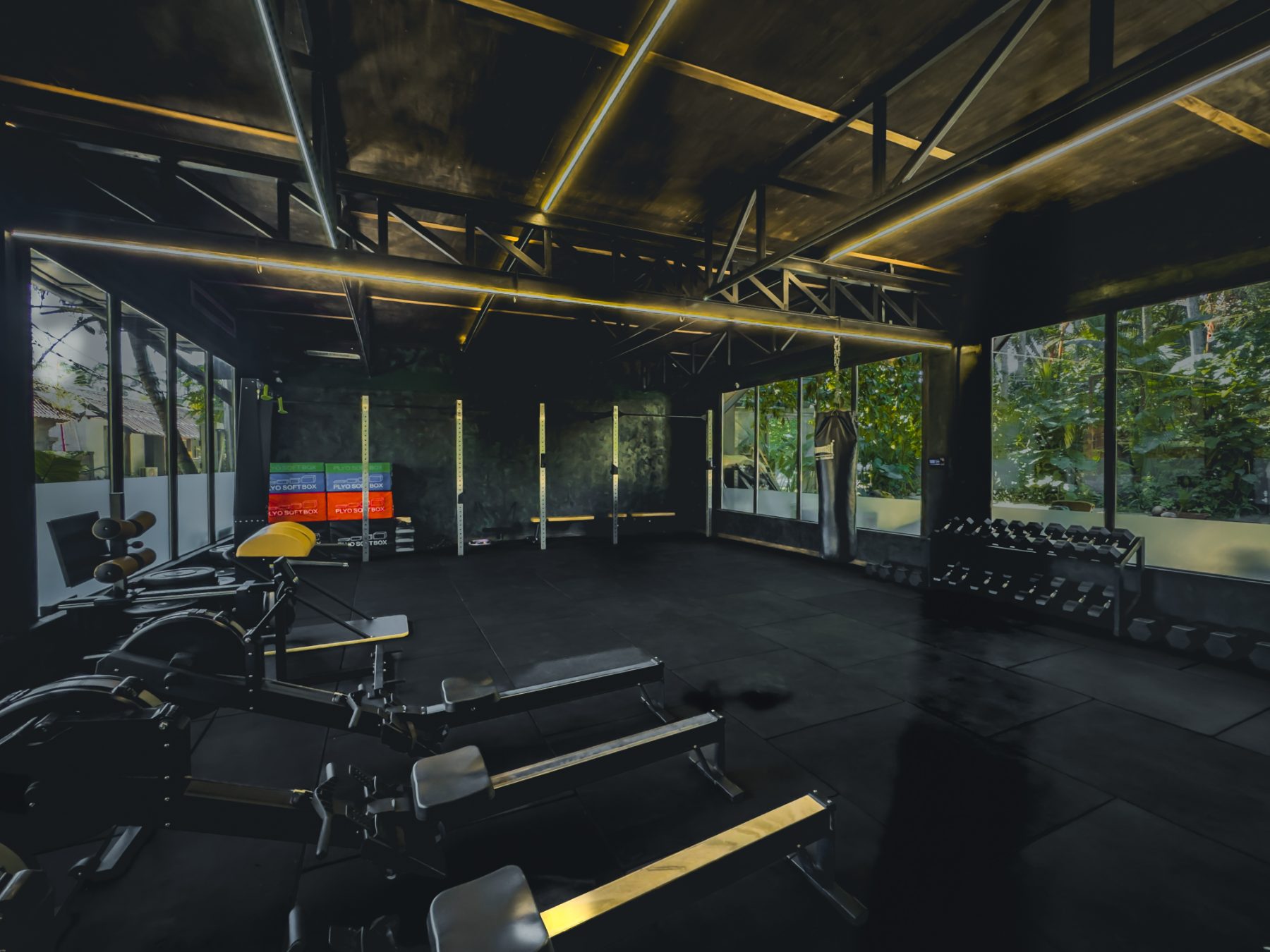 Free-weight floor with racks, benches, dumbbell rack, plyo boxes and a heavy bag