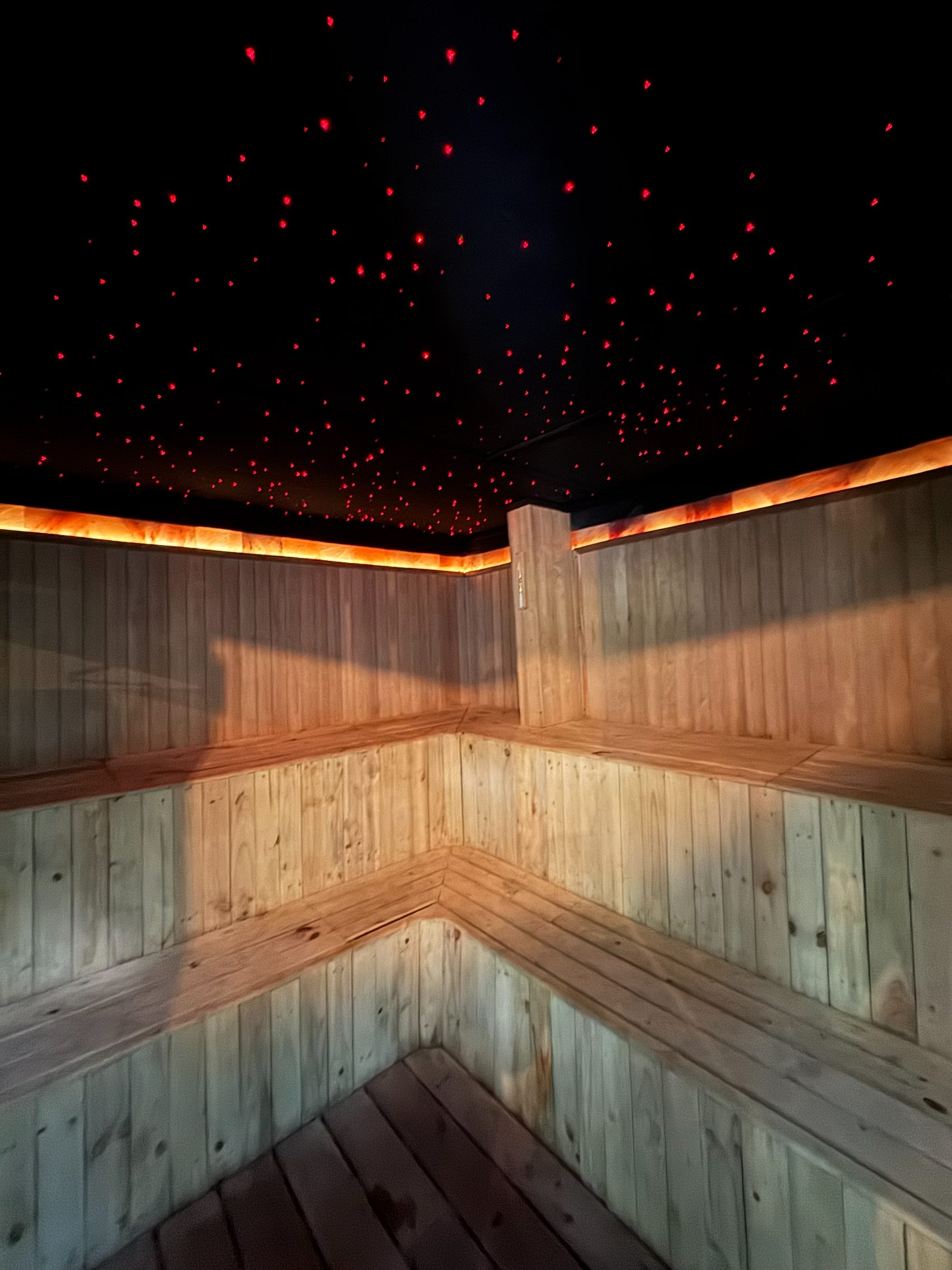 The sauna in pale timber, lit warm