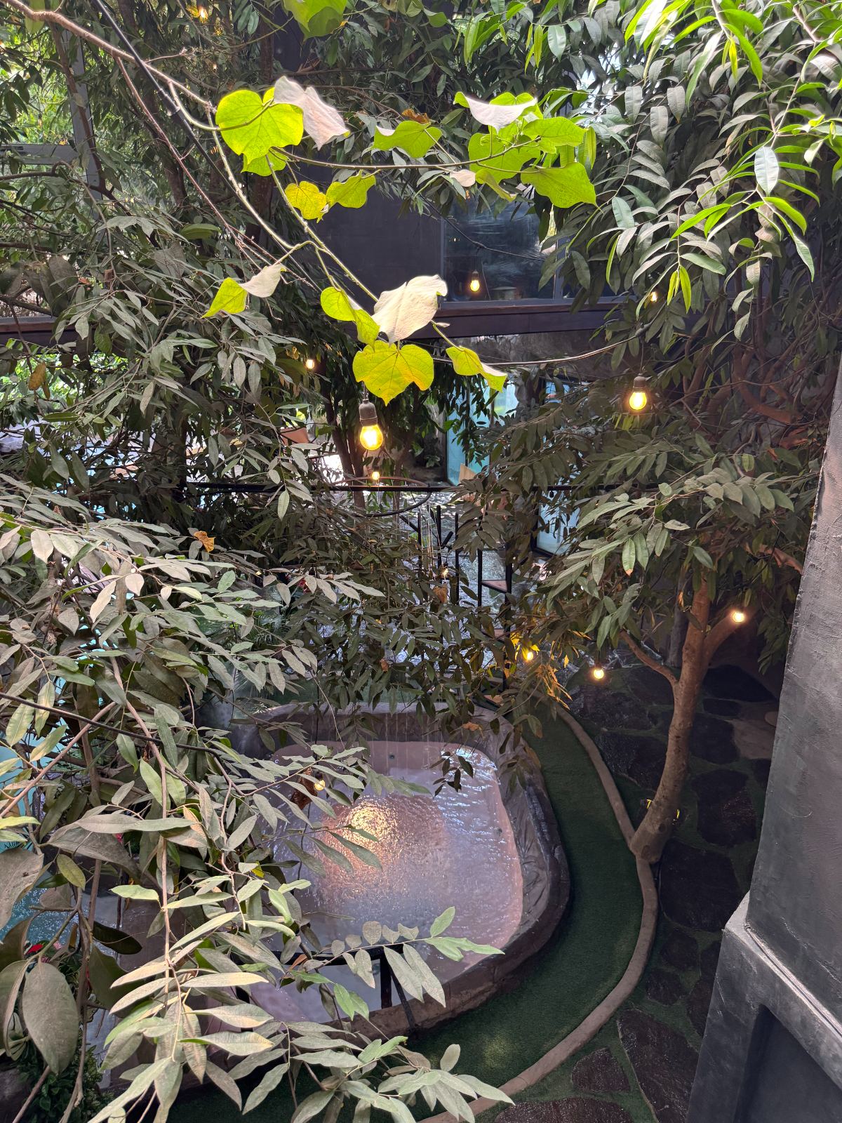 The warm tub at dusk, festoon lights above the water